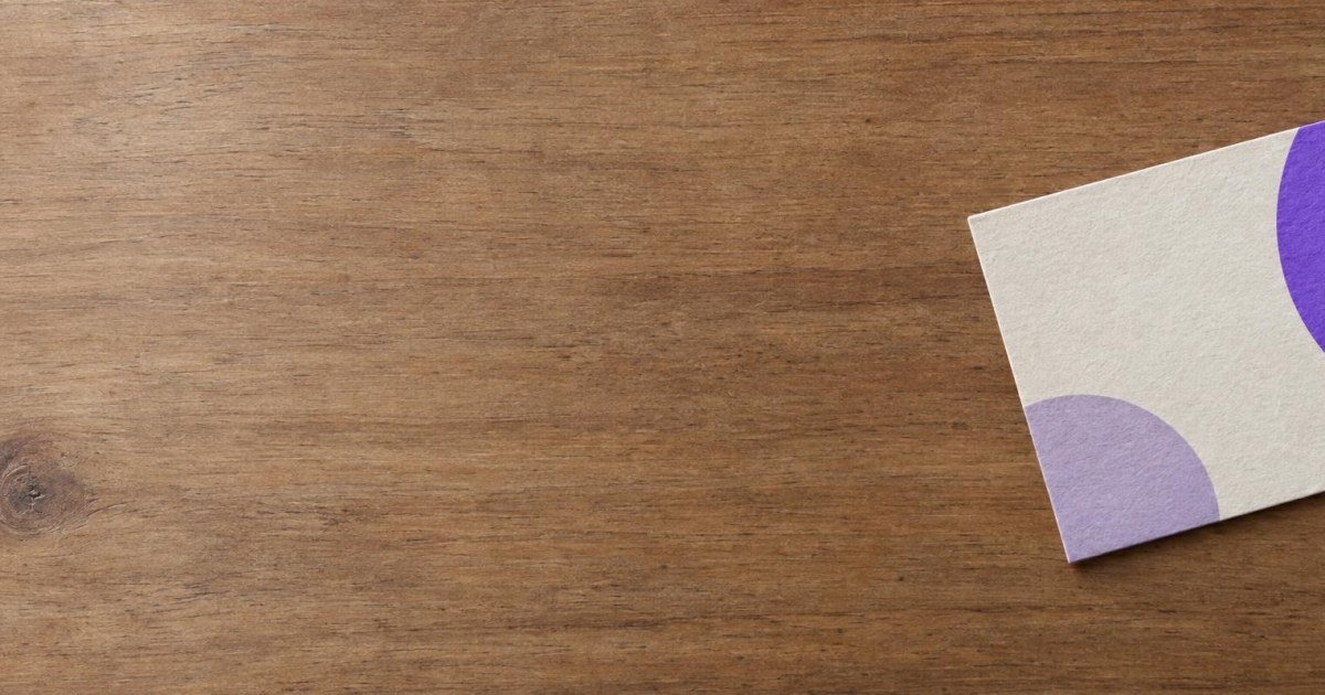 Une carte de visite posée seule sur une table, vue de dessus.